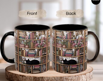 May include: Black coffee mug with a wraparound design of a bookshelf filled with books, flowers, and a sleeping black cat. The mug has a black interior and handle. The mug is sitting on a wooden slice.