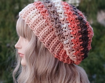 May include: A crocheted beanie hat with a multi-colored striped pattern in shades of brown, peach, coral, and white.