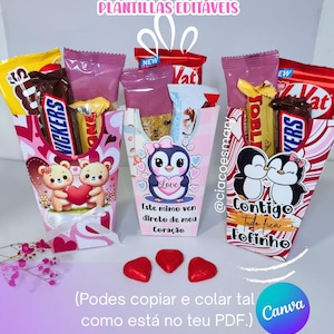 Puede incluir: Tres cajas de regalo decorativas llenas de barras de chocolate y golosinas. Las cajas presentan ilustraciones de osos, pingüinos y corazones. El texto en las cajas incluye "Love" y "Contigo Tudo fica Fofinho". Caramelos rojos en forma de corazón están delante.