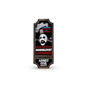 May include: A black and red enamel pin featuring Captain Spaulding's Museum of Monsters and Madmen. The pin depicts Captain Spaulding's face with the text "Fried Chicken! Gasoline! Murder!" and "Admit One 10301977".