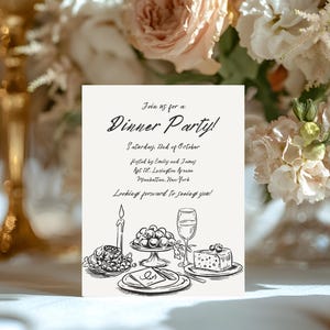 以下が含まれることがあります： 「Join us for a Dinner Party!」と書かれた白いカード。日付、主催者、住所、ワイングラス、チーズ、ブドウ、キャンドルが置かれたテーブルセッティングの手描きイラストも含まれています。