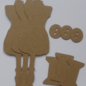 May include: Three brown paper dress forms, three brown paper spools of thread, and three brown paper buttons.