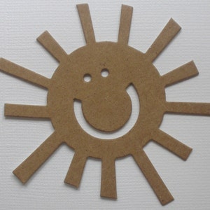 May include: A brown paper cutout of a sun with a smiling face. The sun has 16 rays.