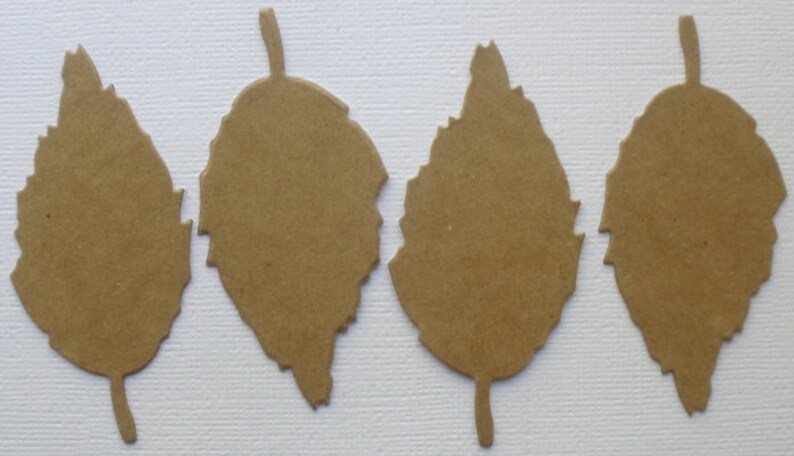 May include: Four brown paper leaves with a jagged edge design. The leaves are cut out and ready to be used for crafting.