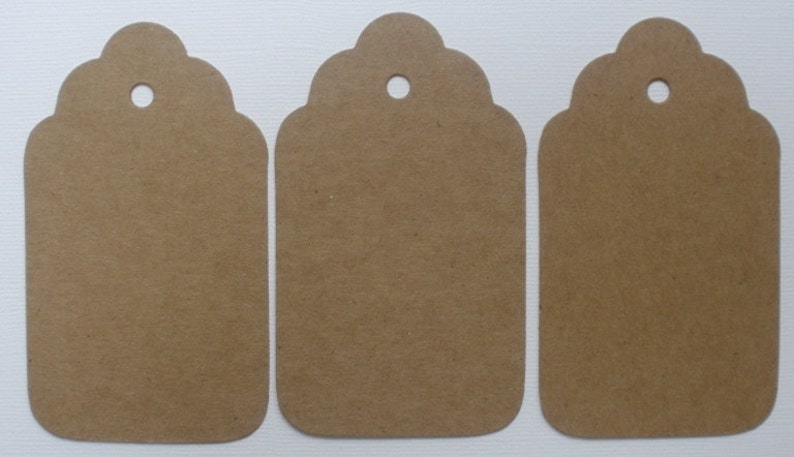 May include: Three brown paper gift tags with scalloped edges and a hole punched at the top.