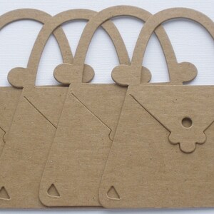 May include: Four brown paper cutouts of handbags with a flower detail on the front. The handbags are all the same size and shape.