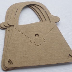 May include: A set of three brown paper handbag cutouts with a flower design.