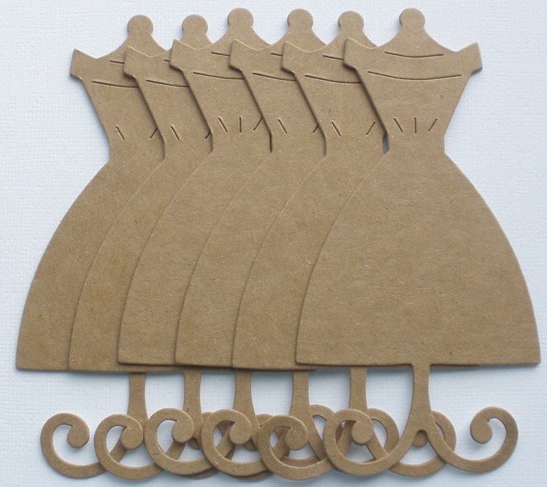 May include: Set of seven brown paper dress cutouts with a decorative swirl at the bottom. The cutouts are perfect for crafting and scrapbooking.