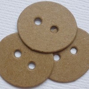 Op de afbeelding: Drie bruine kartonnen knopen met elk twee gaten.