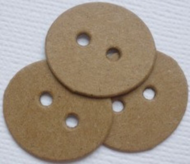Op de afbeelding: Drie bruine kartonnen knopen met elk twee gaten.