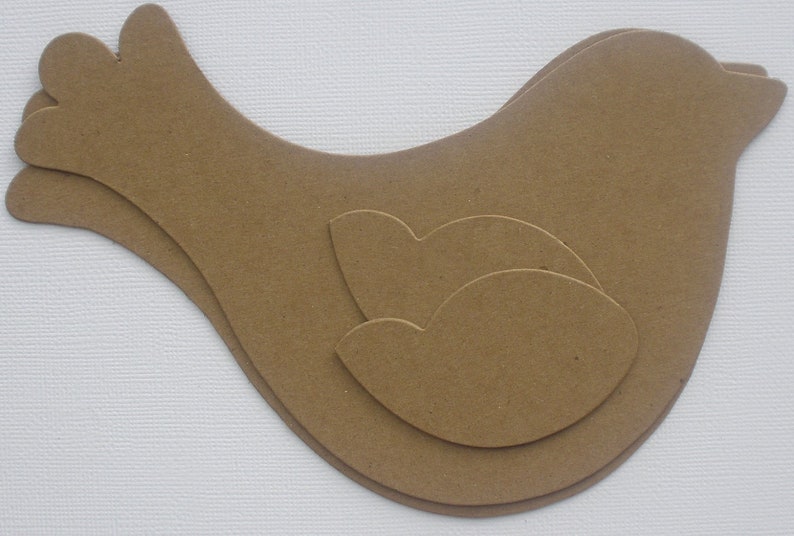 May include: A brown paper bird cutout with a layered design. The bird has a rounded body and a long, pointed beak.