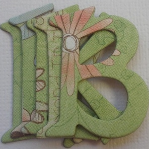 May include: Five green and white patterned wooden letters that spell out the word "B"