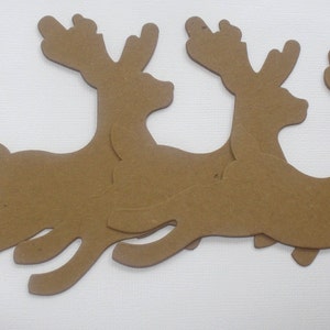 May include: Three brown cardboard reindeer cutouts, each with a unique pose, are arranged in a row. The reindeer are facing the right side of the image.