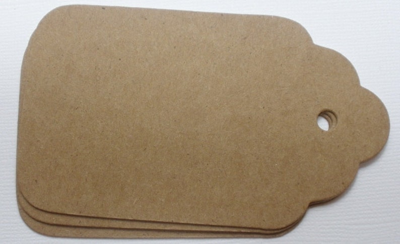 May include: Three brown paper gift tags with scalloped edges and a hole punched in the top.