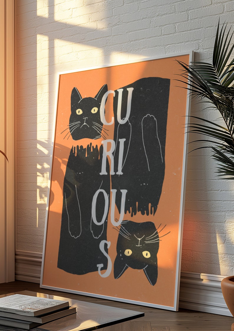 May include: A framed print with an orange background and two black cats. The cats are upside down and the word "CURIOUS" is written vertically in white letters.