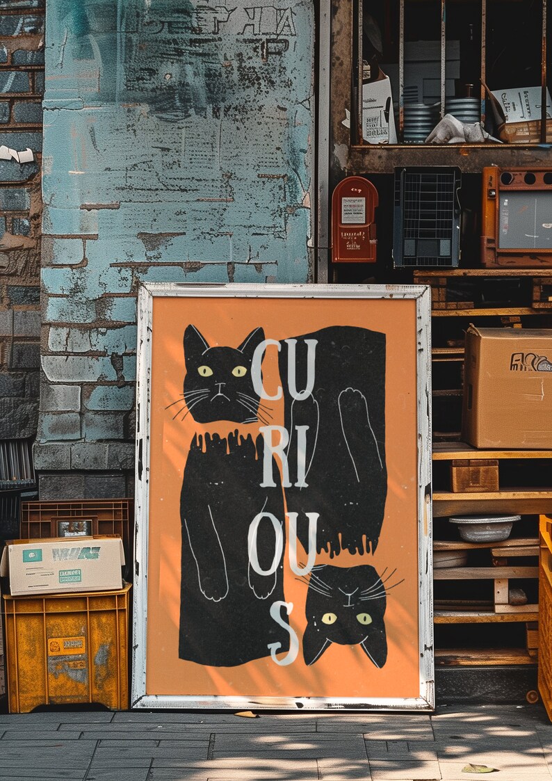 May include: A white framed poster with an orange background and two black cats. The cats are positioned to spell out the word "CURIOUS".