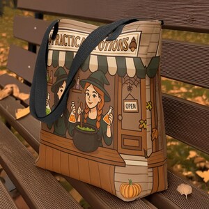 May include: A canvas tote bag featuring a whimsical illustration of a witch shop with the text "PRACTICAL POTIONS". The design includes witches, a cauldron, and a pumpkin, with a black strap. The bag is sitting on a wooden bench.