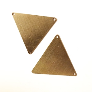 May include: Two gold-toned triangle-shaped metal charms with holes at each corner.