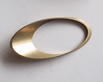 May include: A gold-colored metal ring with a curved, oval shape.