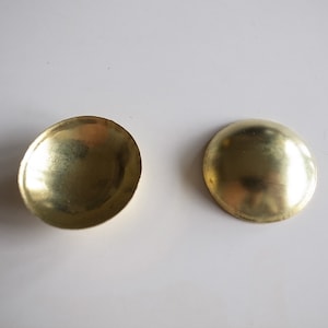 May include: Two gold-colored metal dome-shaped caps.