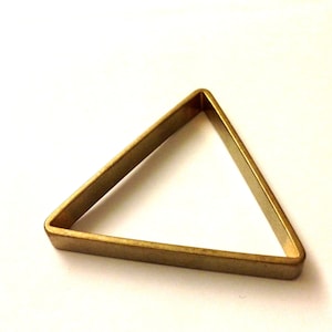 May include: A gold-coloured triangle-shaped ring with a smooth, polished finish.