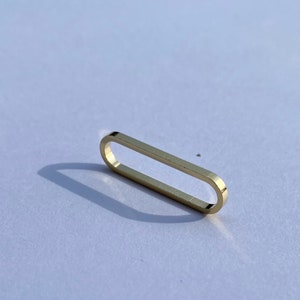 Puede incluir: Un anillo ovalado de oro con un acabado liso y pulido.
