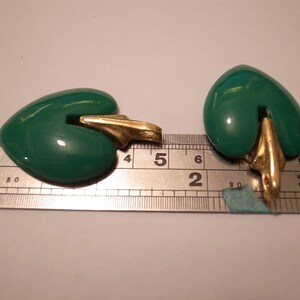 Puede incluir: Dos colgantes en forma de coraz&oacute;n verde con bucles de metal dorado. Los colgantes miden aproximadamente 3,8 cm de largo y se miden con una regla.