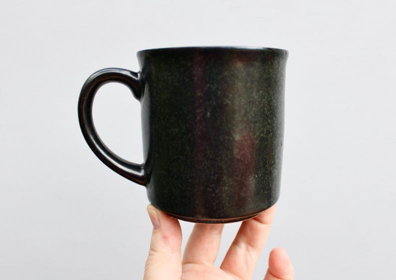 Pu&ograve; includere: Una tazza in ceramica nera con una glassa macchiettata.