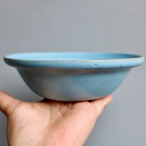 May include: A light blue ceramic bowl with a slightly rounded rim.