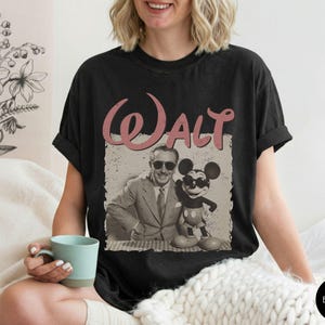 Puede incluir: Camiseta negra con un gr&aacute;fico vintage de Walt Disney y Mickey Mouse. El dise&ntilde;o incluye el nombre "Walt" en una fuente rosa retro. La camiseta es de un estilo c&oacute;modo e informal.