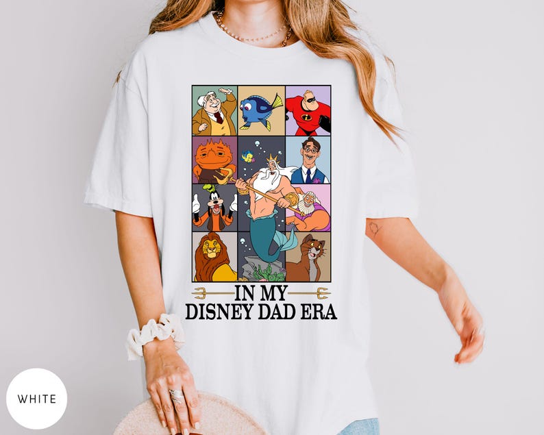 May include: White t-shirt featuring a colorful graphic of Disney characters in a grid pattern. The design includes characters like Mr. Incredible, Dory, and King Triton. The text "IN MY DISNEY DAD ERA" is printed below the grid.