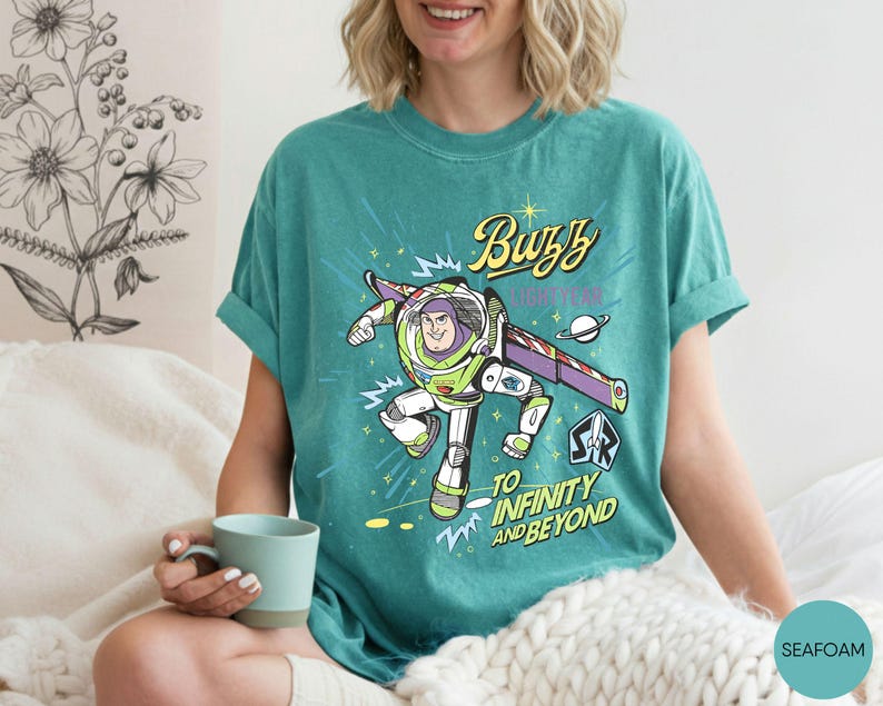 Peut inclure: Une tasse en c&eacute;ramique blanche avec une anse noire et le texte "But First, Coffee" en gras noir. La tasse est pos&eacute;e sur un fond flou, soulignant son design &eacute;pur&eacute;.