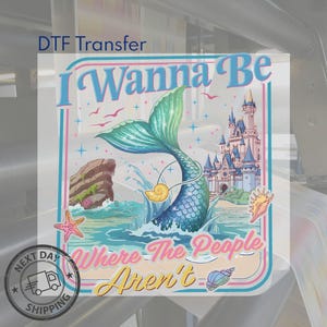 May include: DTF Transfer featuring a mermaid with a teal tail and a castle in the background. The text reads "I Wanna Be Where The People Aren't". The design includes seashells, a starfish, and birds. The image has a retro, cartoon style.