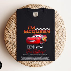 Puede incluir: Camiseta negra con un dise&ntilde;o del personaje Rayo McQueen de la pel&iacute;cula Cars. El dise&ntilde;o incluye el texto "I'm McQueen" y "I am Lightning!" en rojo y amarillo. La camiseta tambi&eacute;n tiene una peque&ntilde;a imagen del personaje.