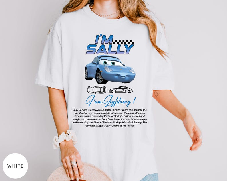Puede incluir: Camiseta blanca con un coche de dibujos animados azul y el texto "I'M SALLY". Debajo del coche est&aacute; el texto "I'am Lightning!". La camiseta tambi&eacute;n tiene texto que describe al personaje Sally Carrera.