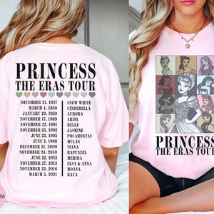 May include: Light pink t-shirt featuring a graphic of Disney princesses in a grid, with the text "PRINCESS THE ERAS TOUR". The back of the shirt lists dates and princess names. A Blossom logo is visible.