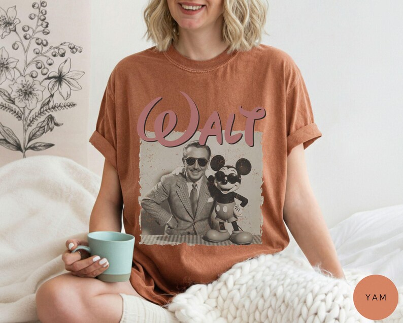 Puede incluir: Una camiseta de color &oacute;xido con un gr&aacute;fico de estilo vintage de Walt Disney y Mickey Mouse. La palabra "Walt" est&aacute; impresa encima de la imagen en rosa, en cursiva. La camiseta tiene mangas cortas y un corte holgado.