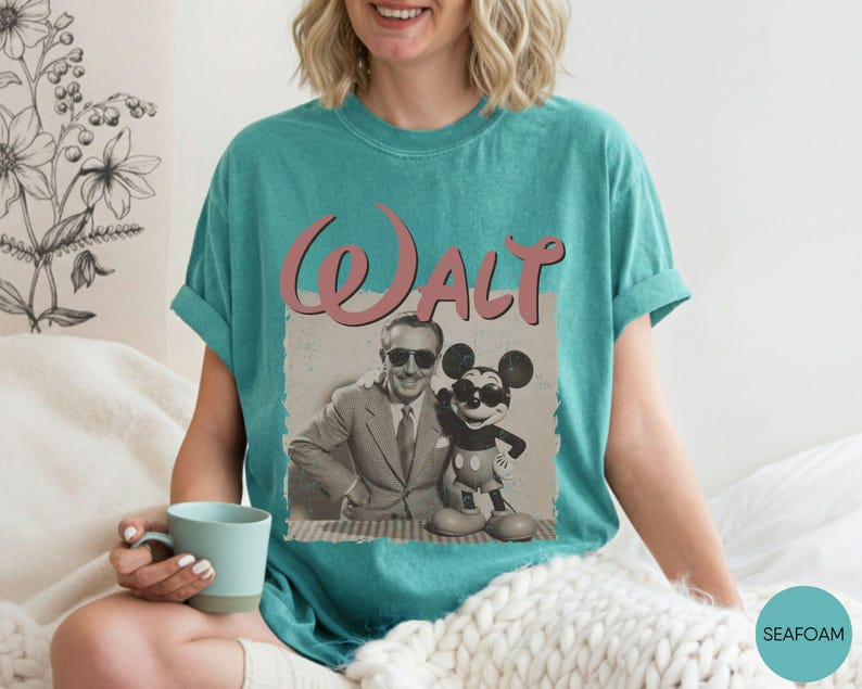 Puede incluir: Camiseta verde mar con un gr&aacute;fico vintage de Walt Disney y Mickey Mouse. El gr&aacute;fico incluye el nombre "Walt" en escritura rosa. La imagen de Walt Disney y Mickey Mouse es en blanco y negro.