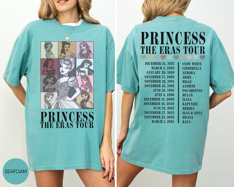 May include: Seafoam green t-shirt featuring a graphic of Disney princesses in a grid, with the text "PRINCESS THE ERAS TOUR." The back of the shirt lists tour dates and princess names. A casual, oversized fit.