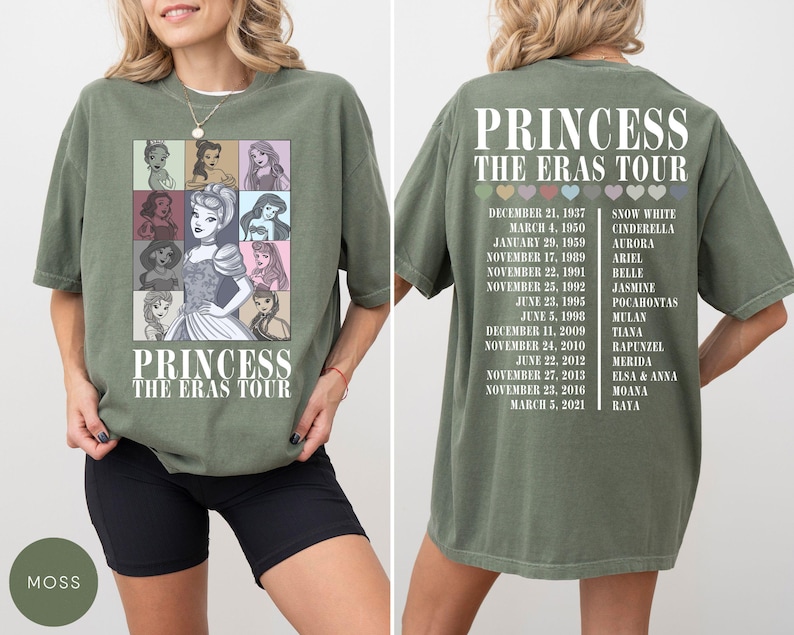 May include: Moss green t-shirt featuring a graphic of Disney princesses and the text "PRINCESS THE ERAS TOUR." The back of the shirt lists princess names and tour dates. The shirt is a comfortable, casual style.