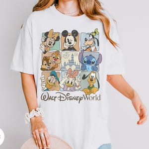 Może przedstawiać: Biała koszulka z siatką postaci Disneya, w tym Myszki Miki i Myszki Minnie, Goofy'ego, Kaczora Donalda i Daisy Duck, Chipa i Dale'a, Stitcha i Pluto. Pod spodem wydrukowano napis "Walt Disney World".