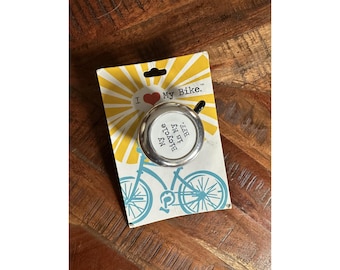 May include: A silver bicycle bell with the text "My Bicycle is My BFF" on a yellow and white card with a bicycle illustration. The card reads "I ❤️ My Bike."