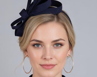 Cappellino con fiocco blu scuro.