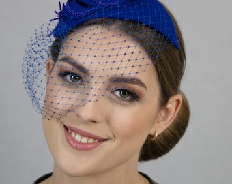 Royal blue fascinator hat with net.