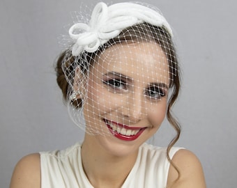 Witte bruidsfascinator met gezichtssluier. Bruiloft hoed voor de bruid. Kerkhoed voor de bruid.