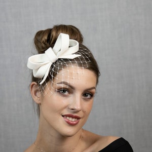 Hellelfenbein oder cremeweißer kleiner Fascinator mit Schleife, wahlweise mit Gesichtsschleier oder auch ohne. Bild 2