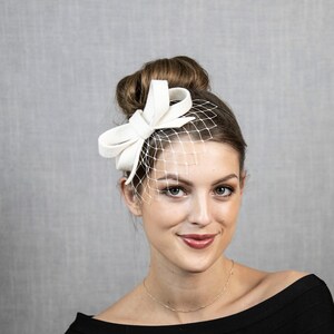 Hellelfenbein oder cremeweißer kleiner Fascinator mit Schleife, wahlweise mit Gesichtsschleier oder auch ohne. Bild 4