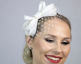 White minimalist bow fascinator with short face veil. New item for 2024 festive occasions.