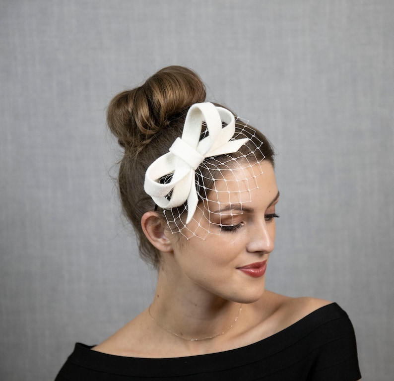 Hellelfenbein oder cremeweißer kleiner Fascinator mit Schleife, wahlweise mit Gesichtsschleier oder auch ohne. Bild 3