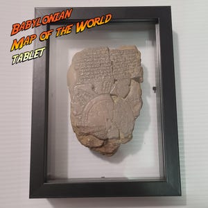 Puede incluir: Tableta enmarcada del Mapa babilónico del mundo. El antiguo artefacto es de color beige y marrón, con escritura cuneiforme visible y un diseño circular. La tableta se exhibe en un marco negro con una cubierta de vidrio transparente. Las palabras "Babylonian Map of the World Tablet" están en la esquina superior izquierda.